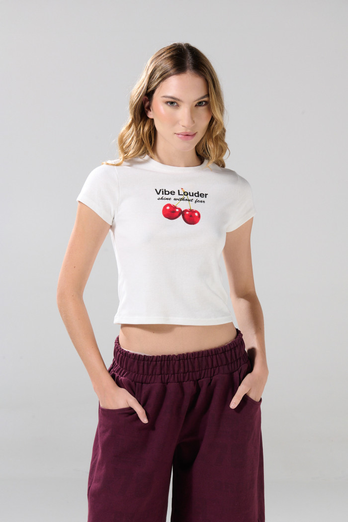 Camiseta crema con cuello redondo y diseño de cerezas