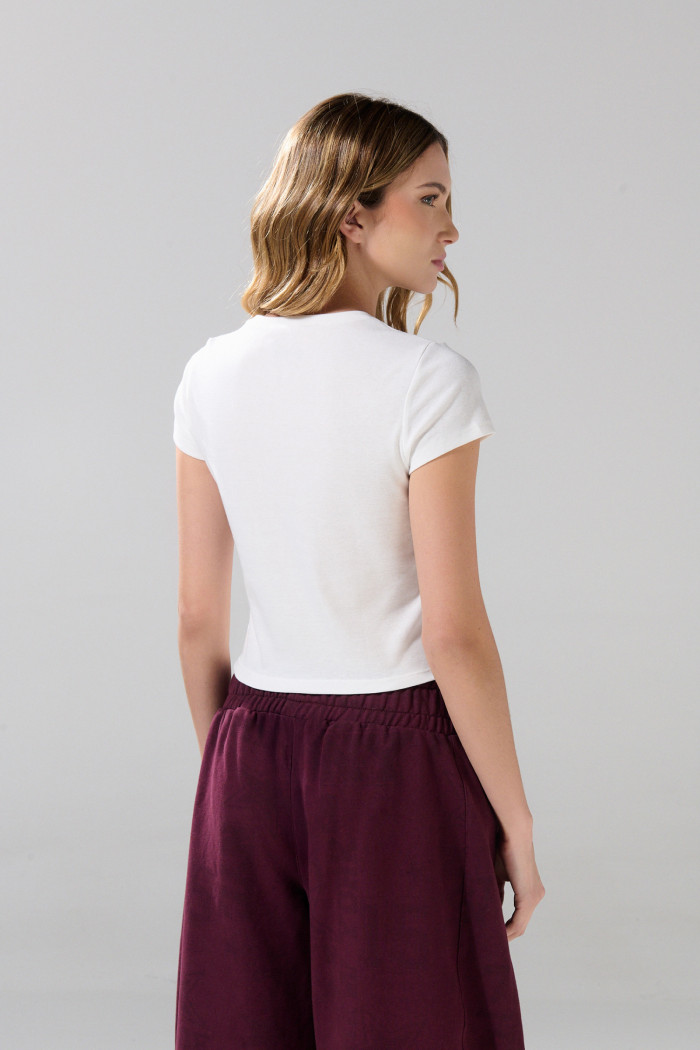 Camiseta crema con cuello redondo y diseño de cerezas