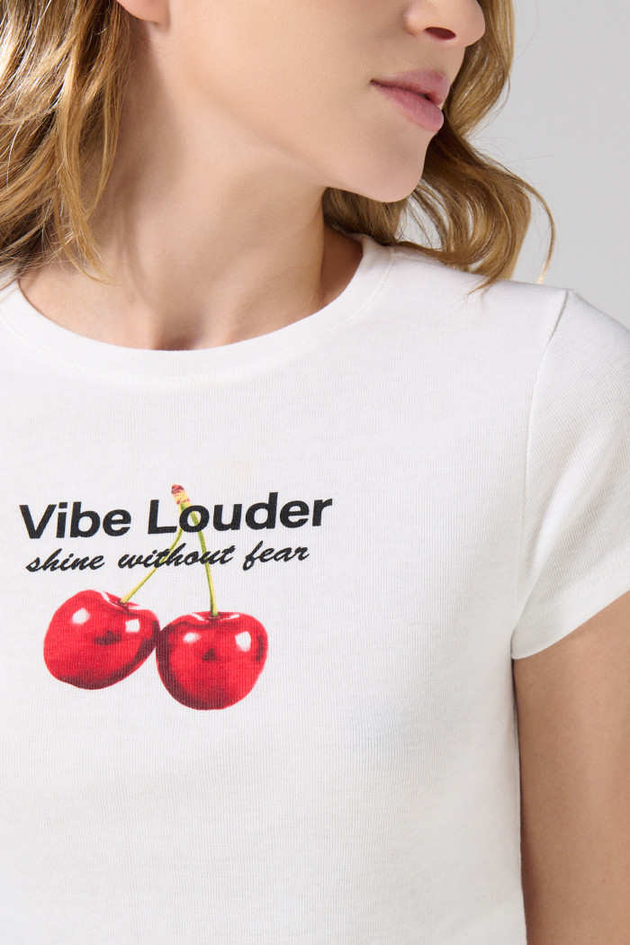 Camiseta crema con cuello redondo y diseño de cerezas