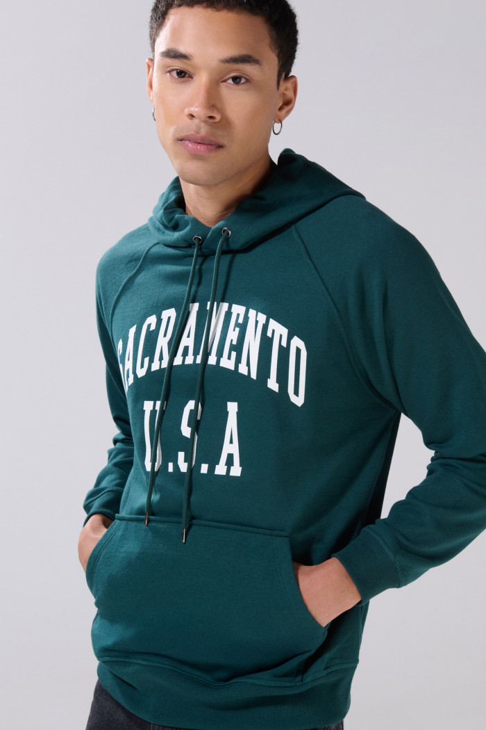 Buzo verde college con manga ranglan y capota