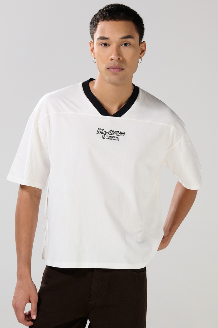 Camiseta oversize cuello V unicolor con diseño college
