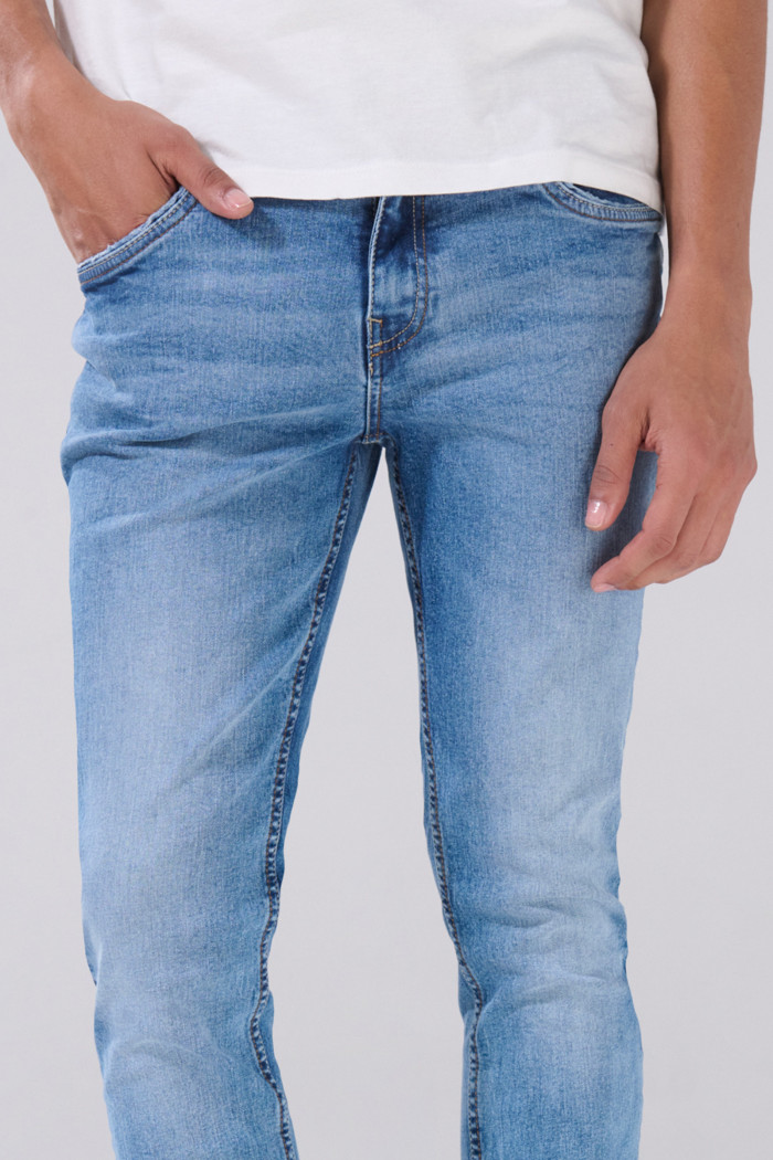 Jean azul claro skinny con desgastes ligeros y tiro bajo
