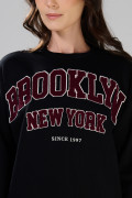 Buzo negro oversize cuello redondo con arte college