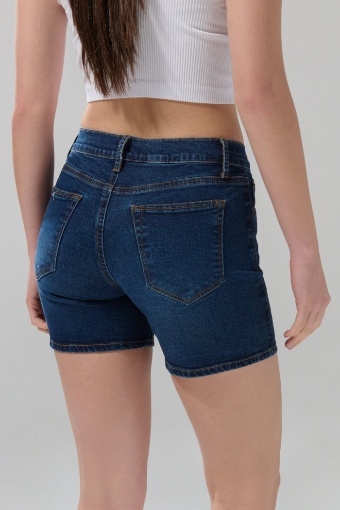 Short azul oscuro de jean tiro medio con 5 bolsillos