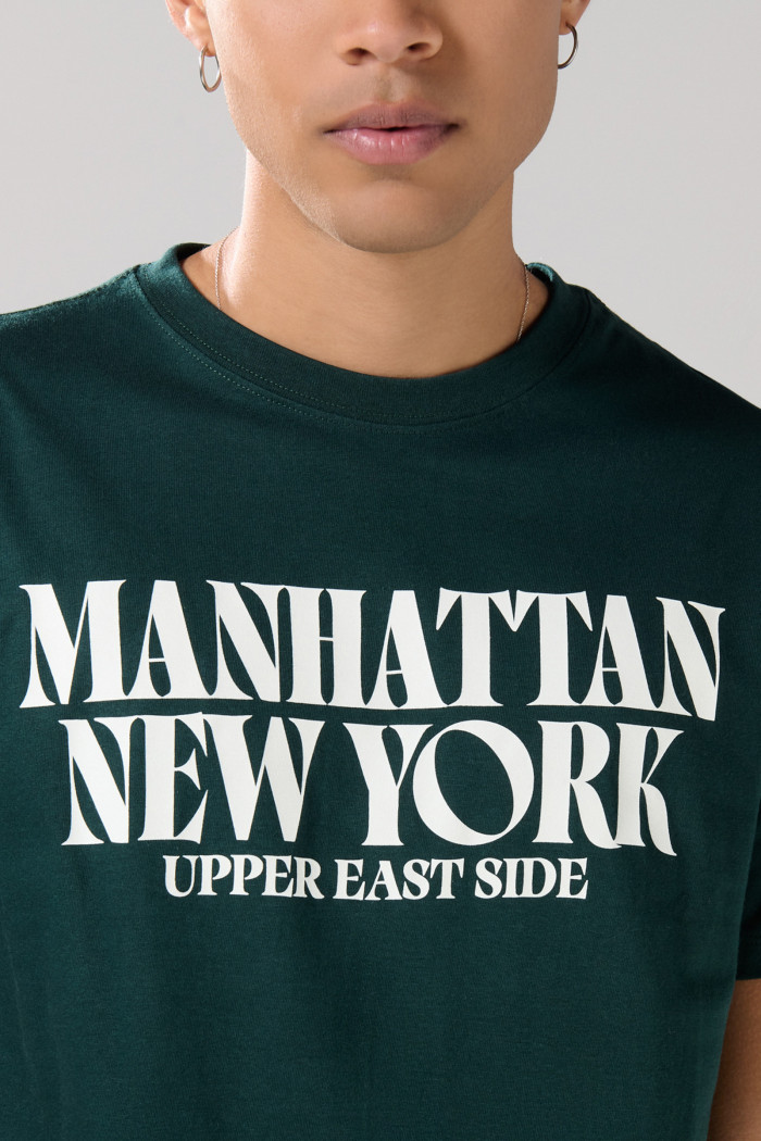 Camiseta verde oscura con cuello redondo y texto college