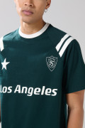 Camiseta verde oscura con manga ranglan y arte college