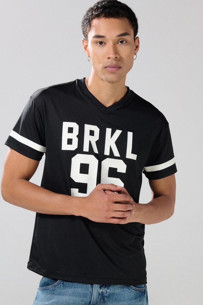 Camiseta negra con estampados college y cuello V