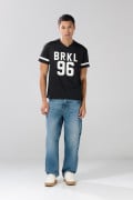 Camiseta negra con estampados college y cuello V