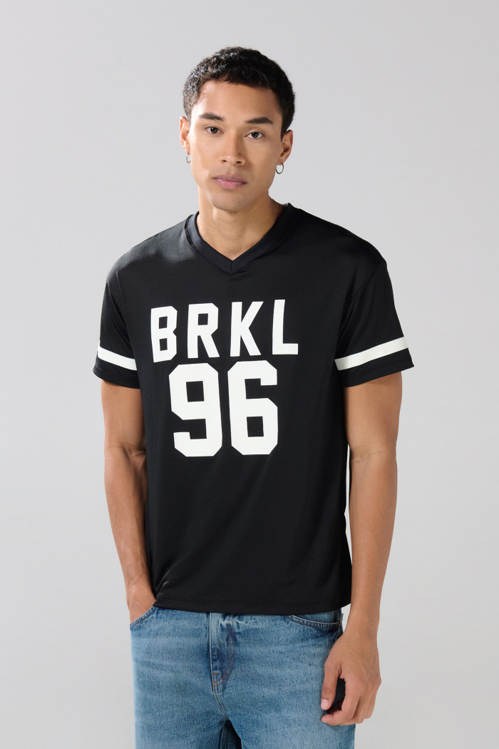 Camiseta negra con estampados college y cuello V