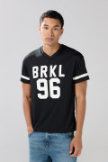 Camiseta negra con estampados college y cuello V