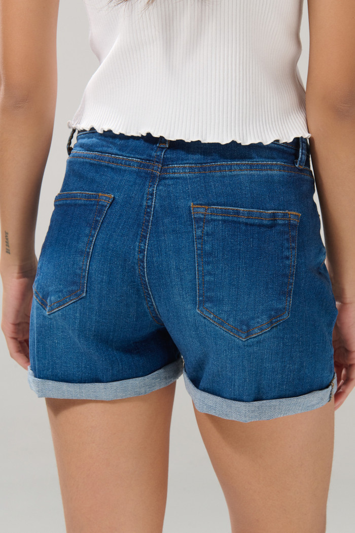 Short tiro alto de jean azul medio con ligeros desgastes