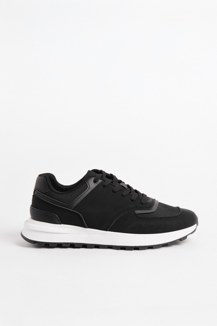 Tenis casuales negros con suelas blancas y cordones
