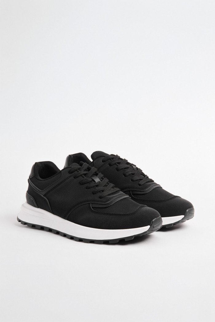 Tenis casuales negros con suelas blancas y cordones