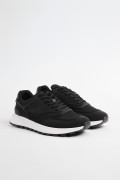 Tenis casuales negros con suelas blancas y cordones