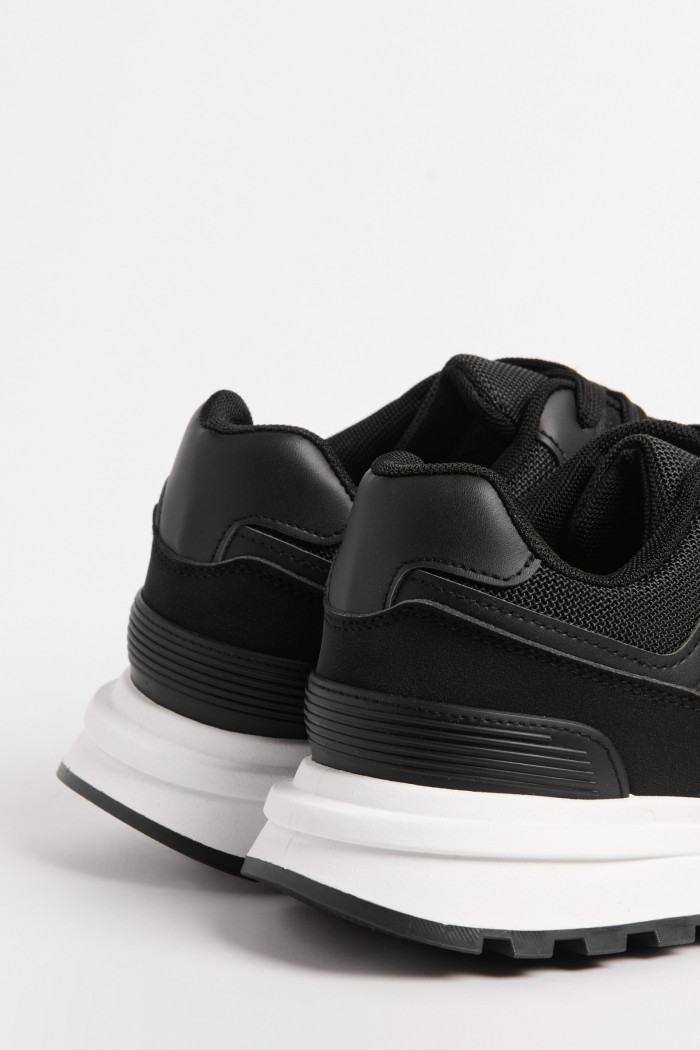 Tenis casuales negros con suelas blancas y cordones