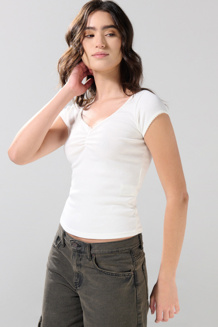 Camiseta blanca con escote en V y recogido en frente