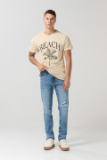Jean slim azul claro con rotos, tiro bajo y desgastes