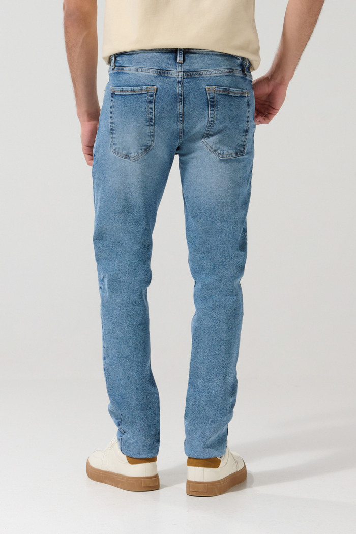 Jean slim azul claro con rotos, tiro bajo y desgastes