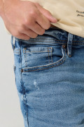 Jean slim azul claro con rotos, tiro bajo y desgastes