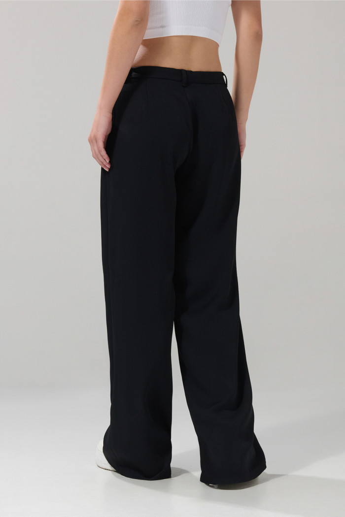 Pantalón tiro medio palazzo negro con bota ancha