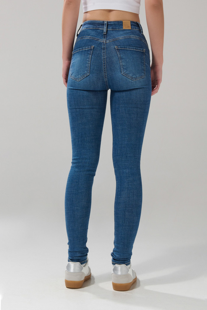 Jean azul medio push up con desgastes, bolsillos y tiro alto