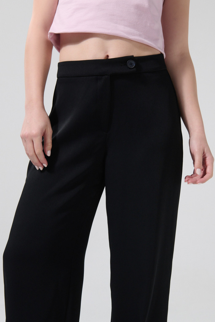 Pantalón negro con bota recta, tiro alto y prenses