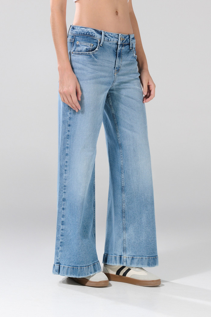 Jean flare azul claro con bota ancha, tiro medio y desgastes