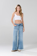Jean flare azul claro con bota ancha, tiro medio y desgastes