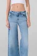 Jean flare azul claro con bota ancha, tiro medio y desgastes