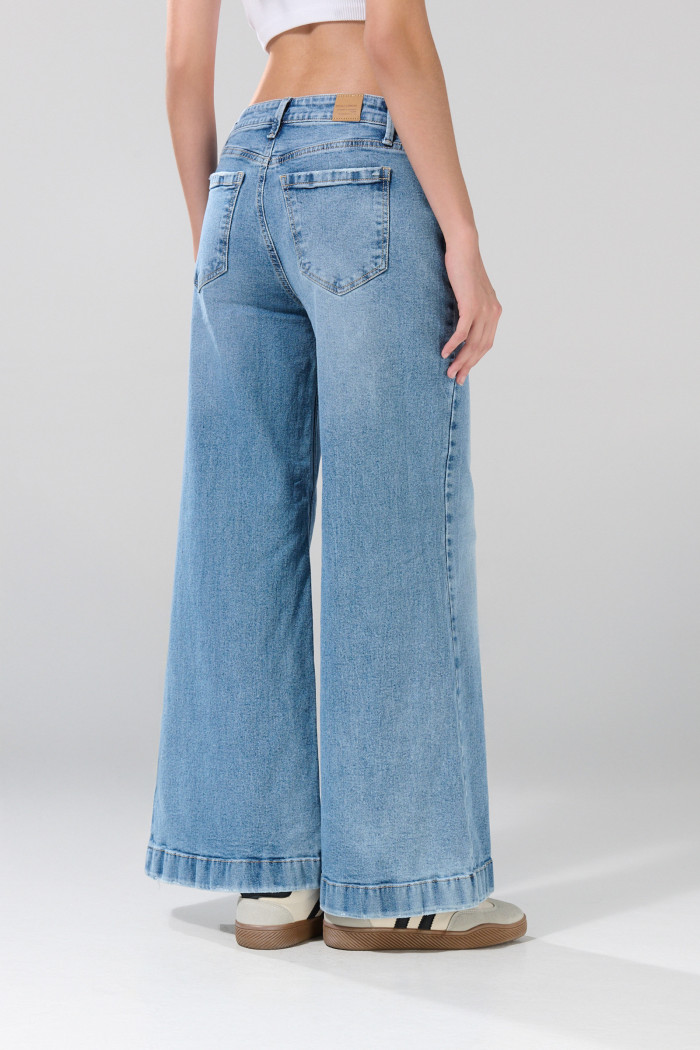 Jean flare azul claro con bota ancha, tiro medio y desgastes