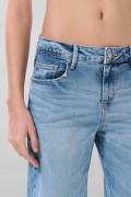 Jean flare azul claro con bota ancha, tiro medio y desgastes