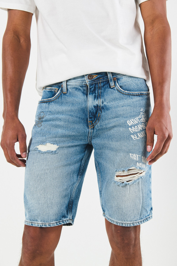 Bermuda en jean slim azul con tiro bajo, diseños y rotos