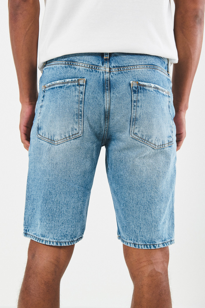 Bermuda en jean slim azul con tiro bajo, diseños y rotos