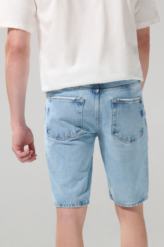 Bermuda de jean azul slim tiro bajo con rotos en frente