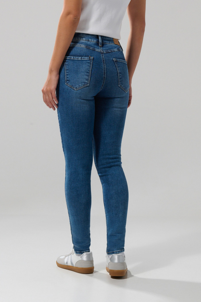 Jean tiro alto jegging azul medio con desgastes y cremallera