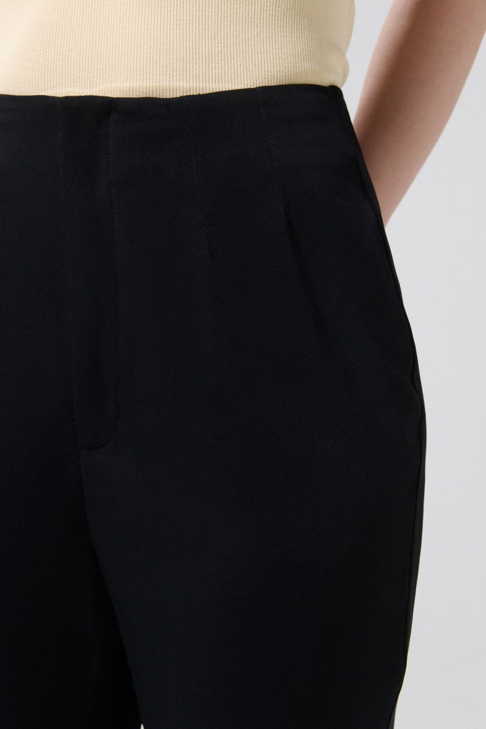 Pantalón negro flare tiro alto con aberturas y bota ancha