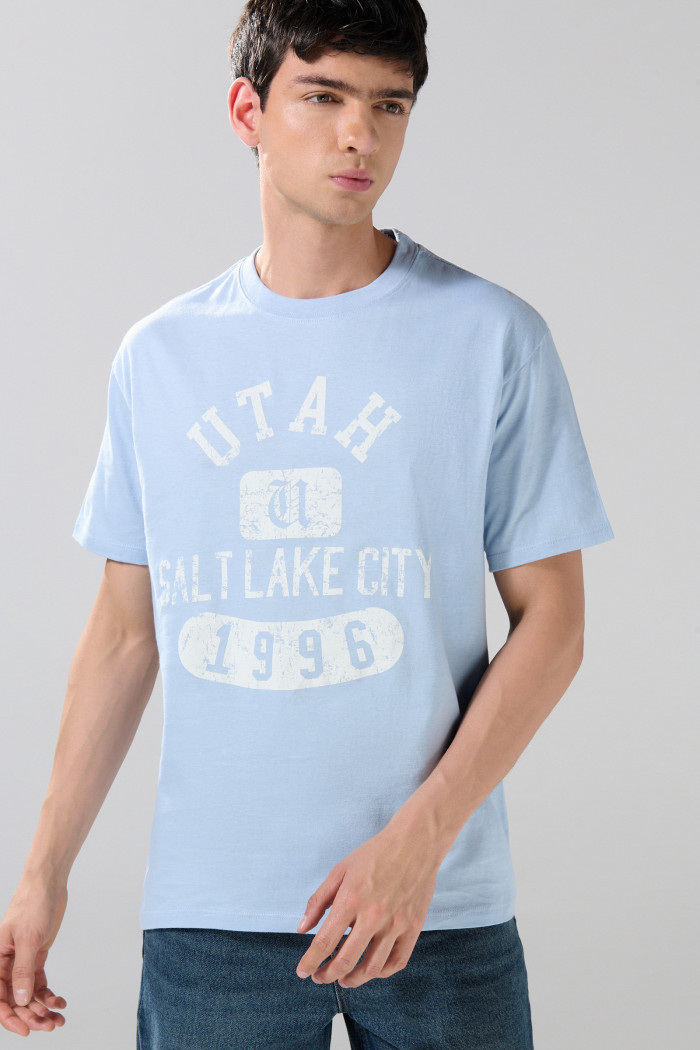 Camiseta azul clara manga corta con texto college blanco