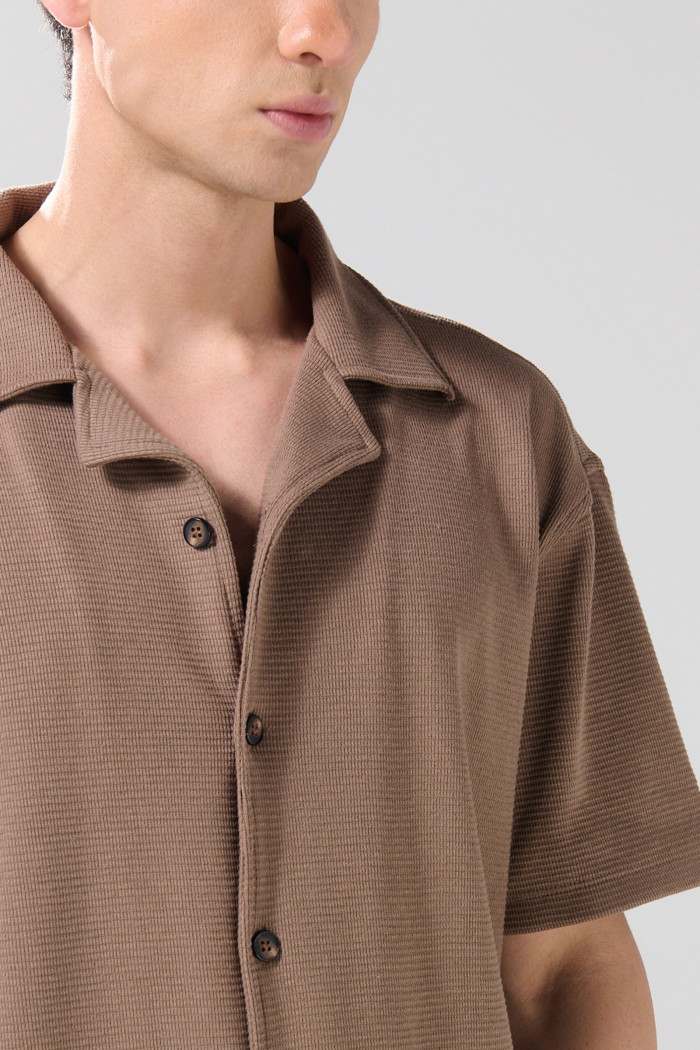 Camisa café oscura con diseños estampados y cuello resort