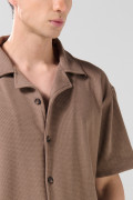 Camisa café oscura con diseños estampados y cuello resort