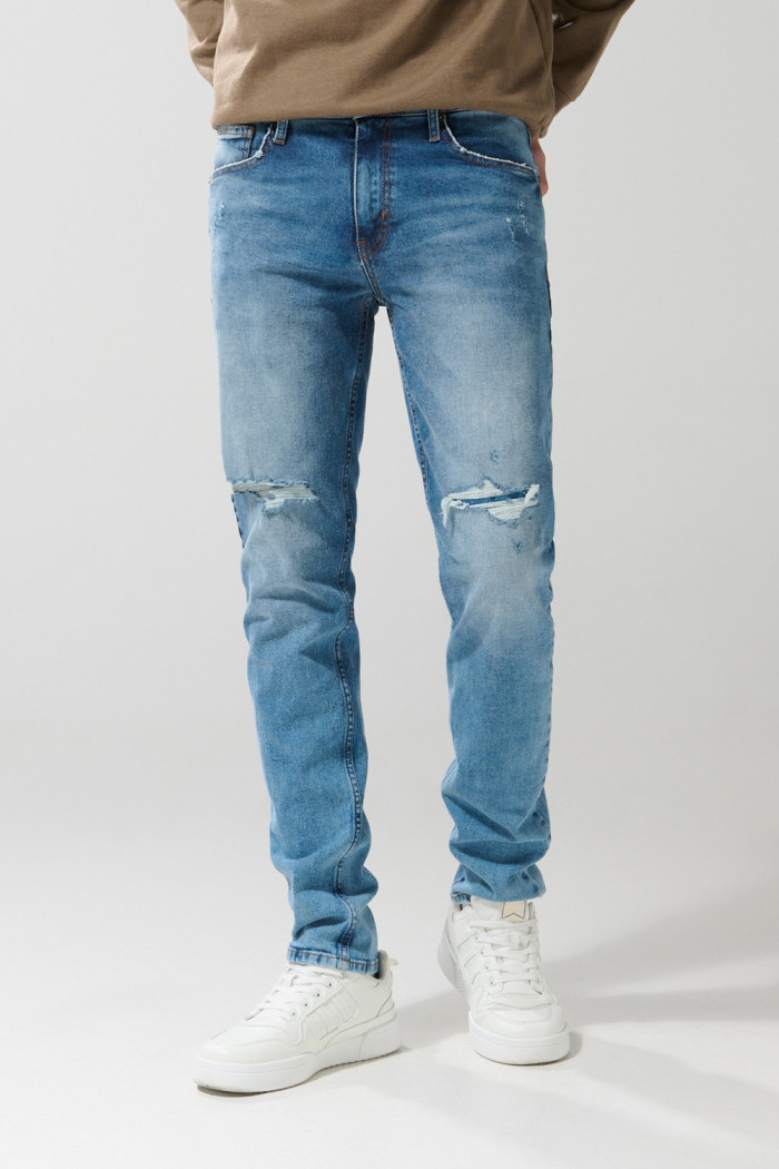 Jean slim azul oscuro con tiro bajo, rotos y desgastes