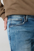Jean slim azul oscuro con tiro bajo, rotos y desgastes