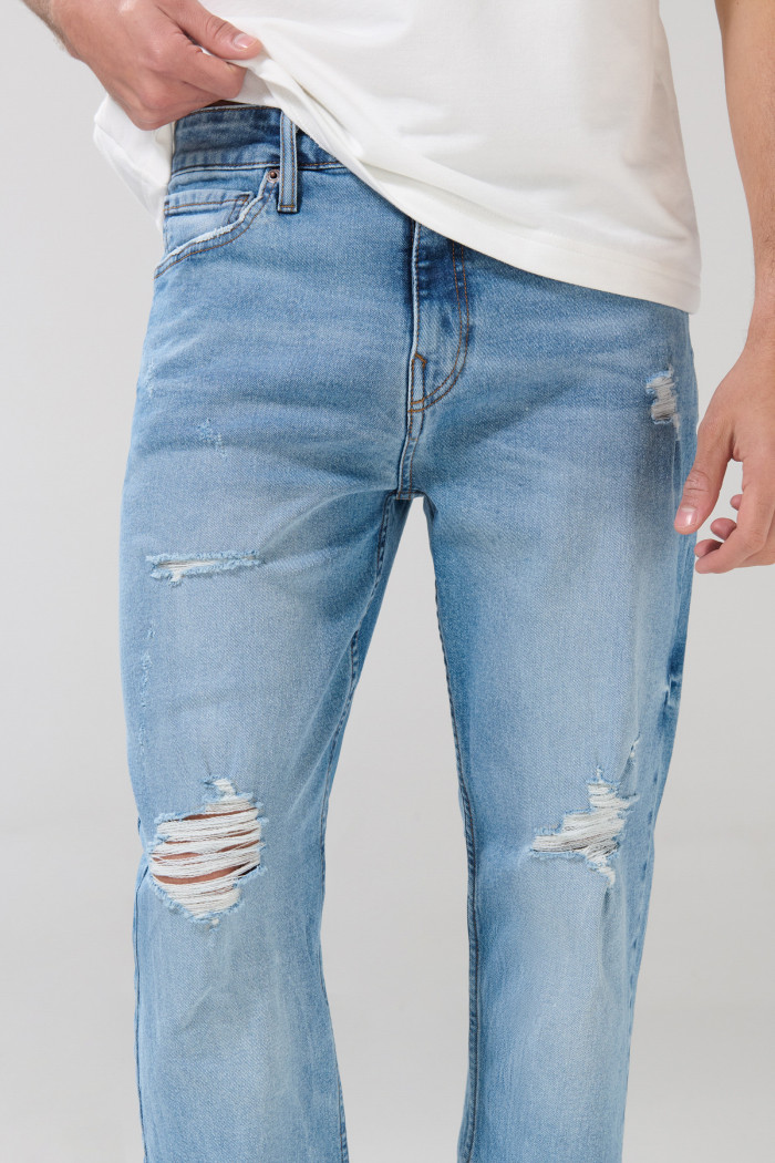 Jean straight leg azul con tiro bajo, desgastes y rotos
