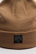 Gorro tejido unicolor con marquilla decorativa en frente
