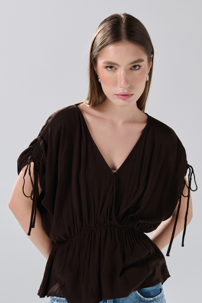 Blusa unicolor con elástico en cintura y manga larga