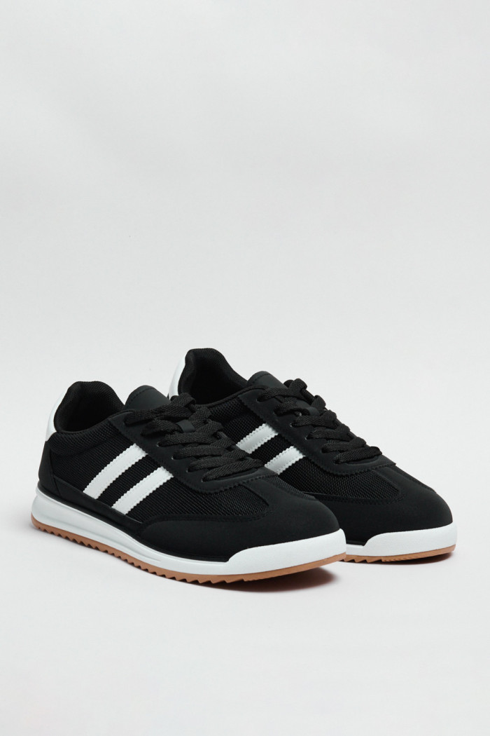 Tenis negros casuales con contrastes blancos y cordones