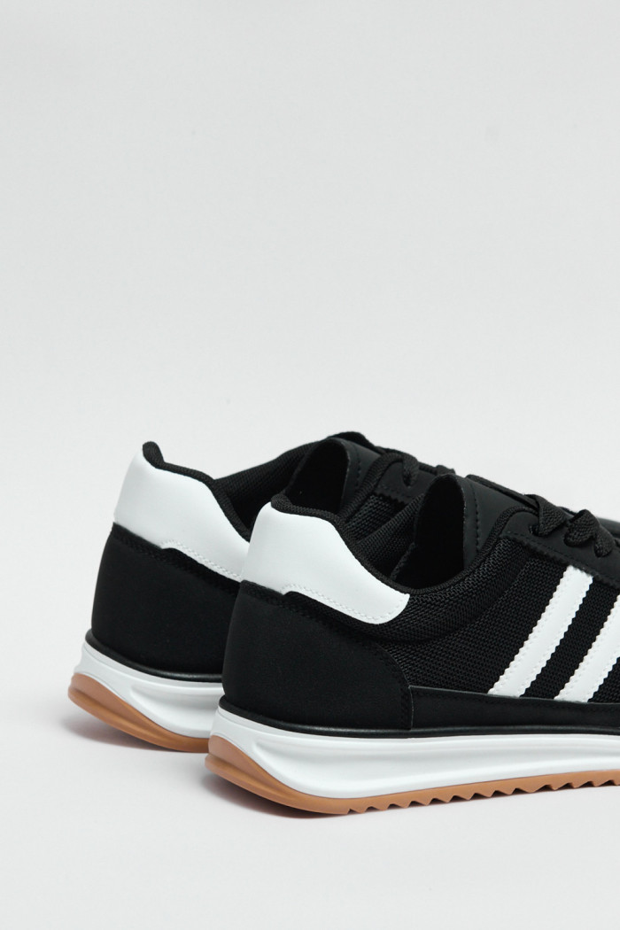 Tenis negros casuales con contrastes blancos y cordones