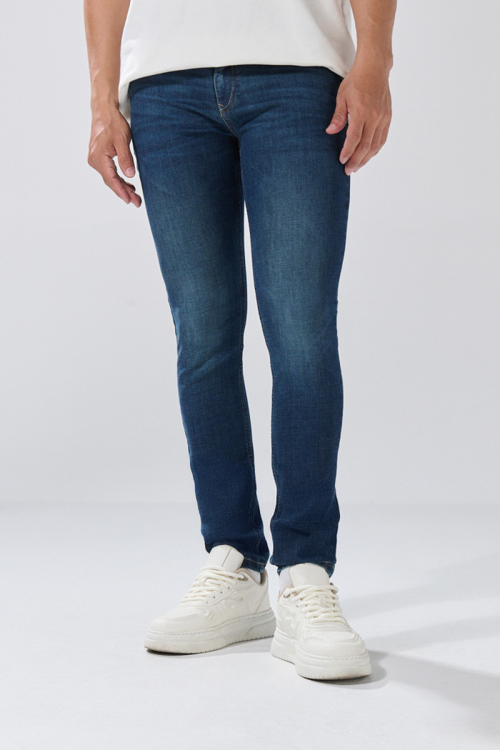 Jean tiro bajo skinny azul oscuro con costuras visibles
