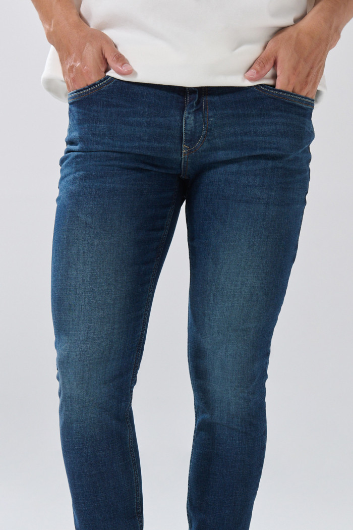Jean tiro bajo skinny azul oscuro con costuras visibles
