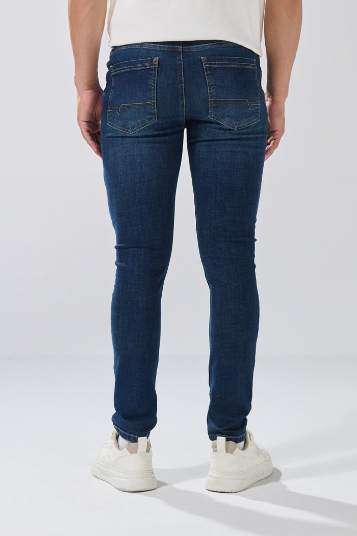 Jean tiro bajo skinny azul oscuro con costuras visibles
