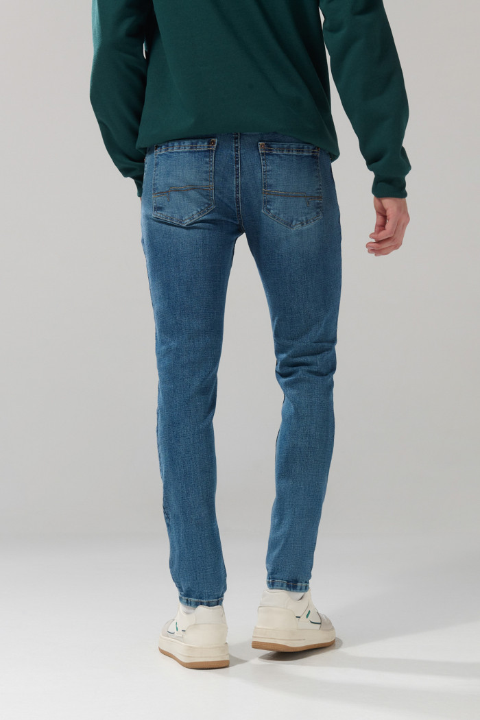 Jean skinny ajustado azul medio con tiro bajo y desgastes